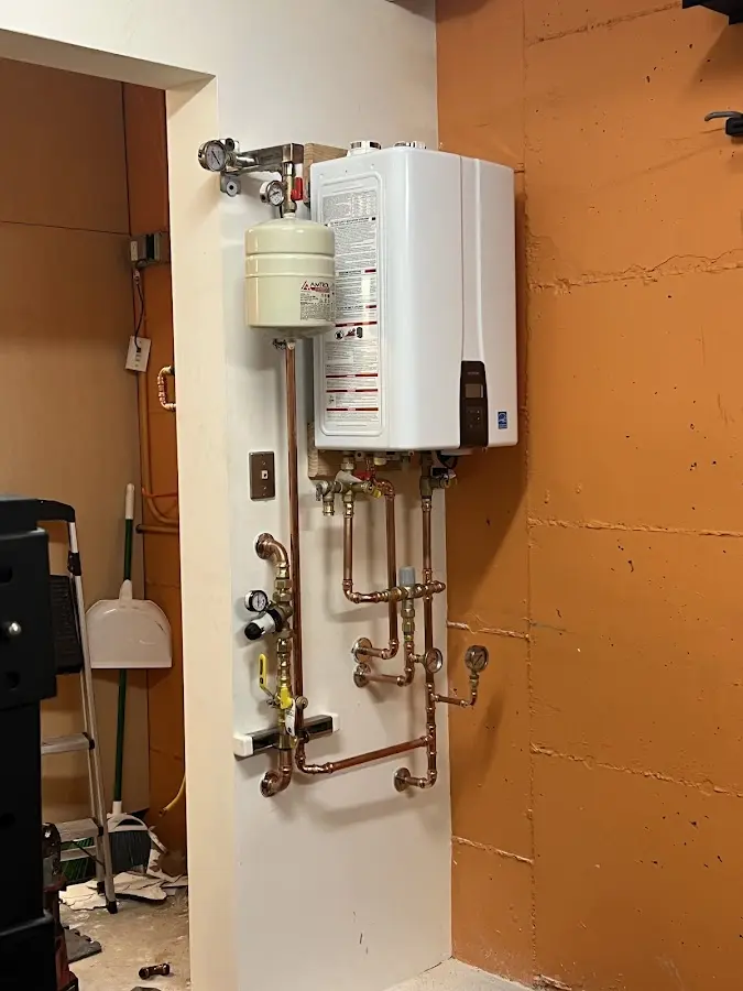 Plumbing technician inspecting water heater connections in DeSoto